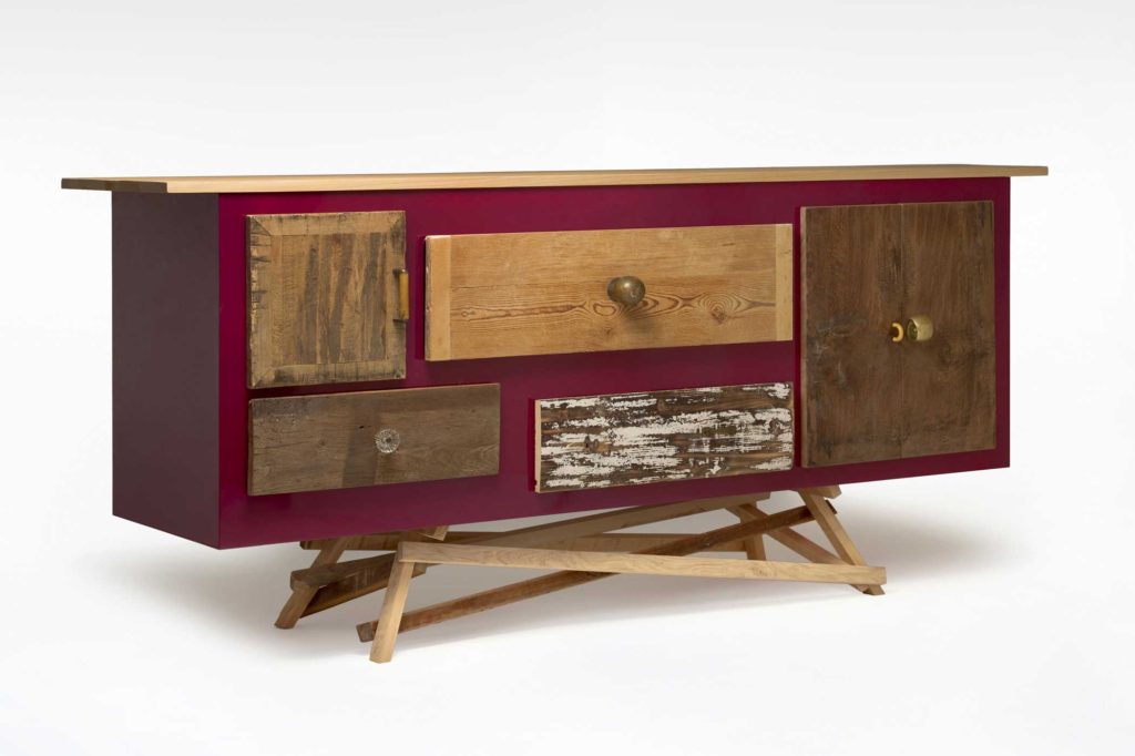Credenza su misura con struttura laccata lucida tra il bordeaux e il violaceo e cassetti di legno vintage scrostato.