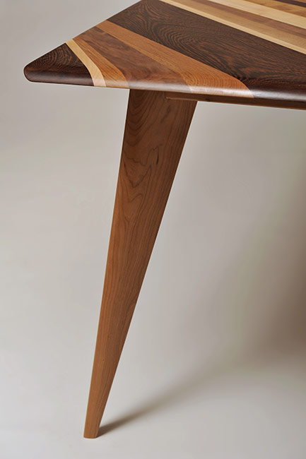 Tavolo con piano fatto di assi irregolari di legno massello. Tavolo con piano in noce, acero, wengè, teak.