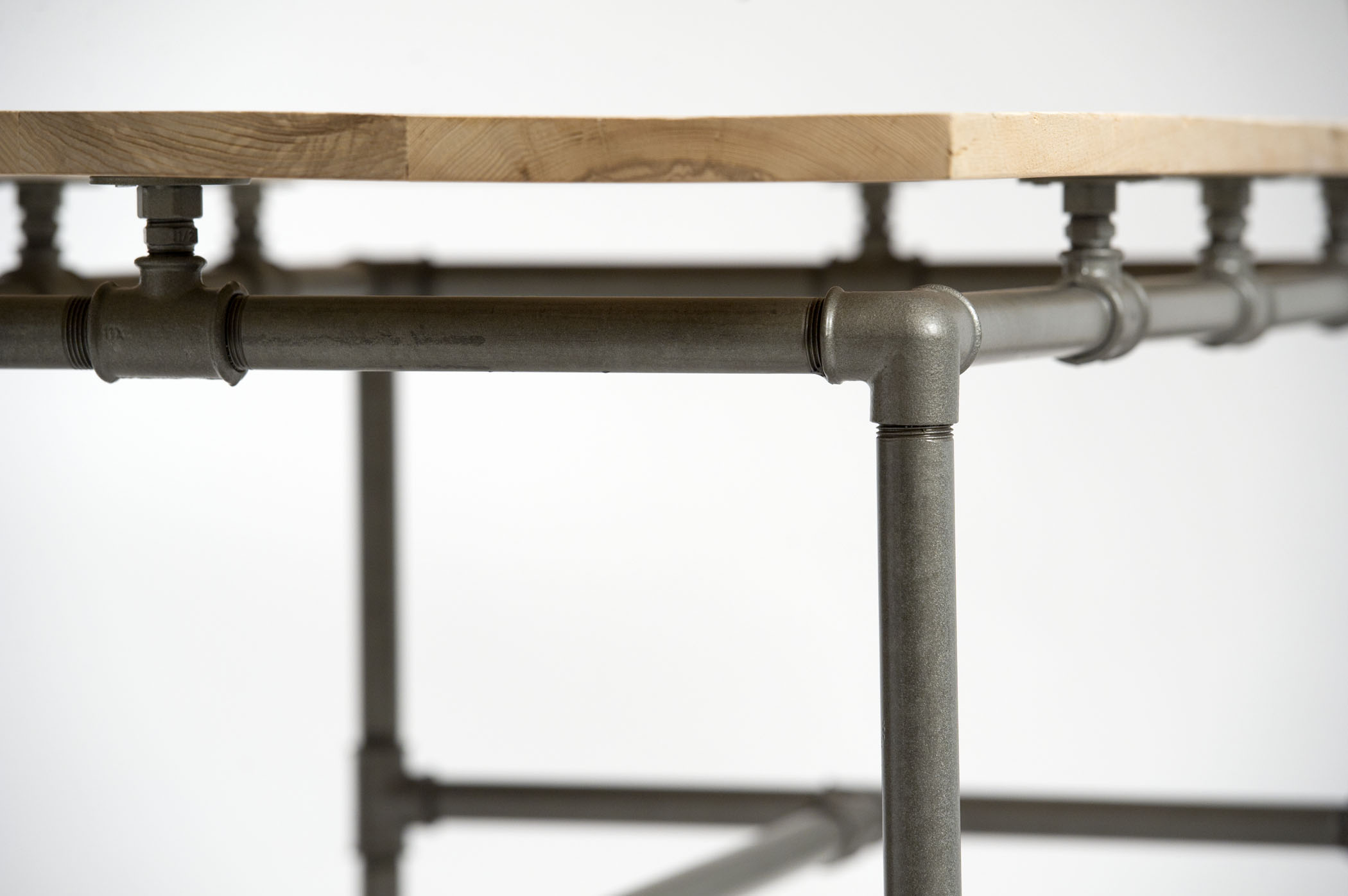 Tavolo con piano fatto con listelli da costruzione di legno restaurato e gambe costruite con tubi idraulici