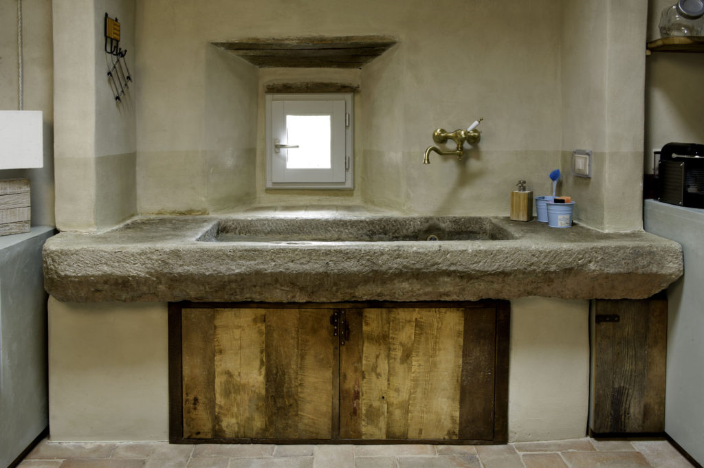 Lavabo in pietra in una cucina con legno vintage