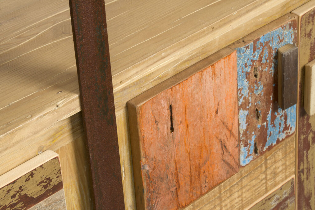 Dettaglio di una libreria in legno di recupero e ferro. Il legno di recupero è abete al naturale e colorato arancio, azzurro e marrone.