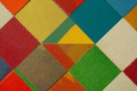 Qbert, madia colorata struttura in legno multistrato, rivestimento con mosaico di tessere di legno decorate con microcemento colorato. ante e gambe in legno massello di rovere. la madia dispone di 2 cassetti e 2 vani chiusi da ante
