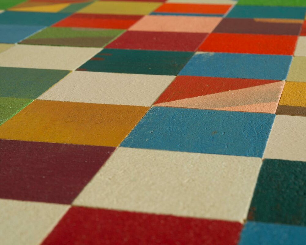 Struttura di una madia colorata composta da quadratini di legno decorati con diversi colori e microcemento