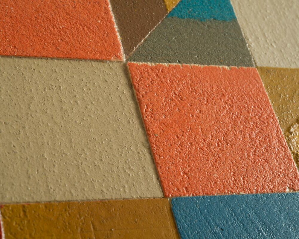 Dettaglio della credenza alta e stretta colorata composta da quadratini di legno decorati con microcemento multicolore