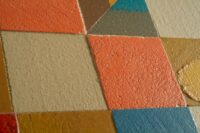 Dettaglio della credenza alta e stretta colorata composta da quadratini di legno decorati con microcemento multicolore