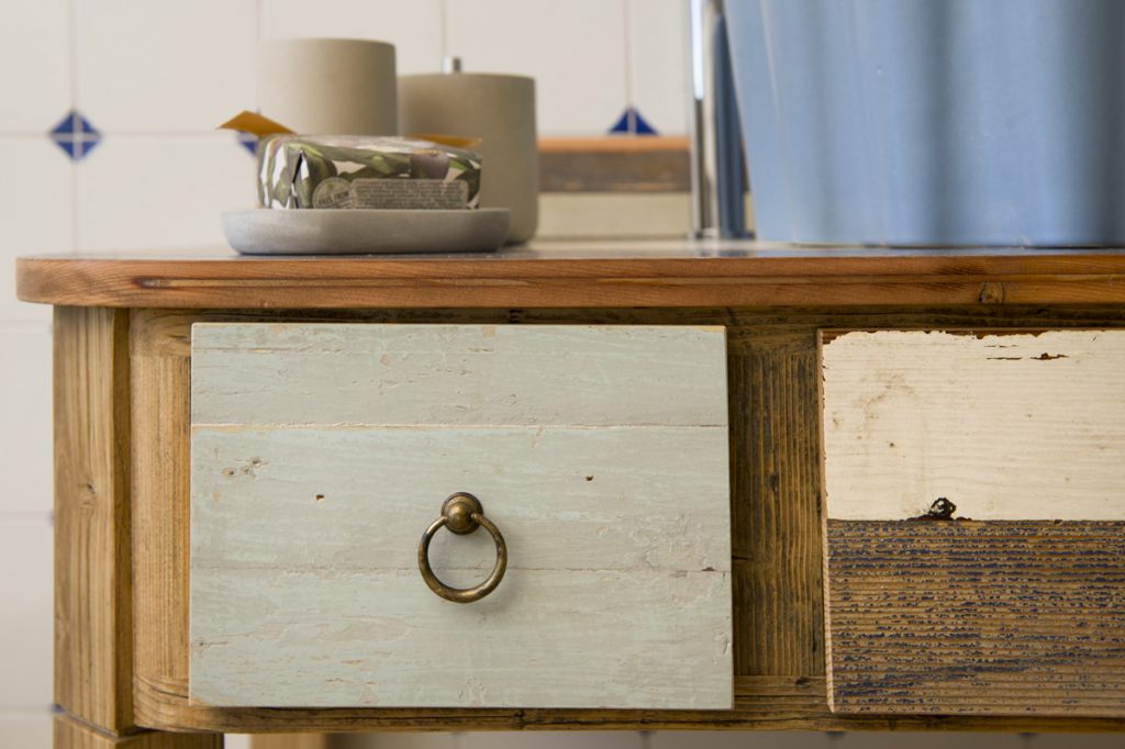 particolare di un mobile lavabo in legno rustico con cassetti in legno di recupero colorato