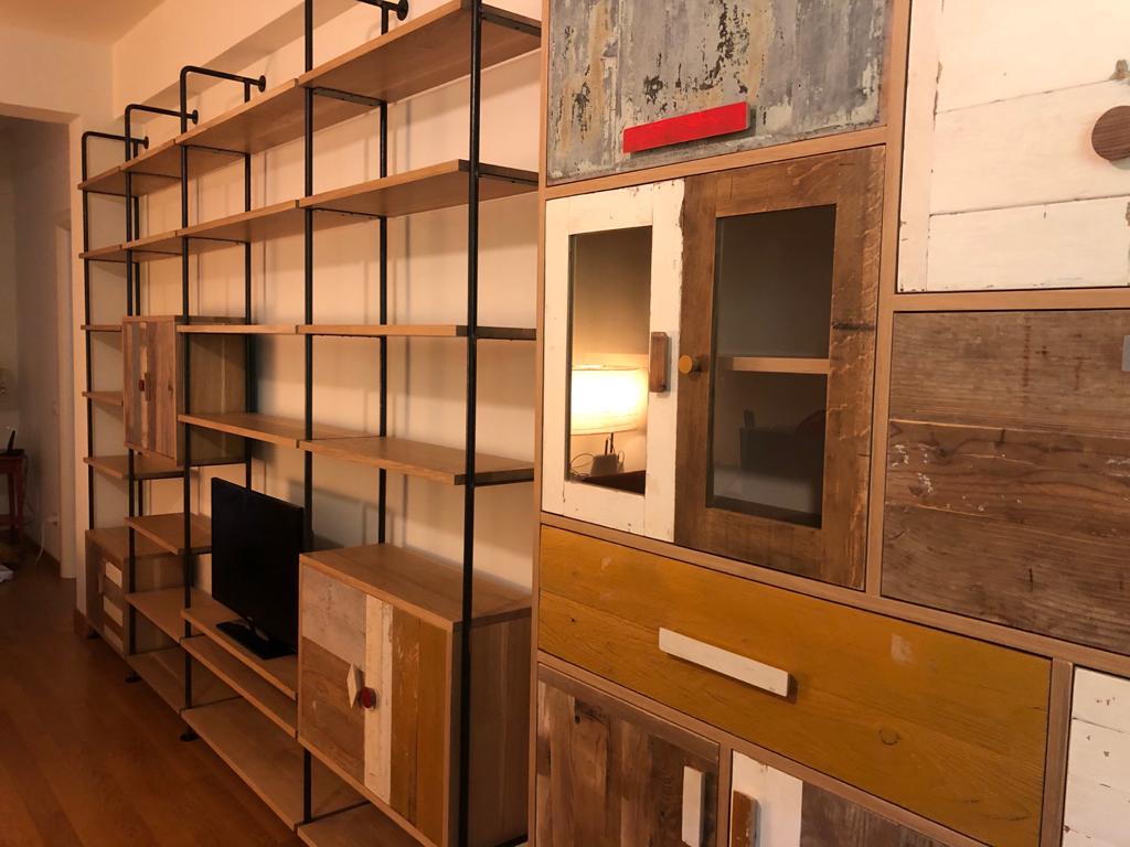 libreria in ferro e legno con dispensa accordata con i moduli della libreria, sportelli in legno di recupero colorato e al naturale