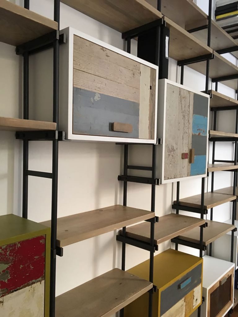 libreria in stile industriale con moduli contenitori laccati e sportelli in legno grezzo e colorato