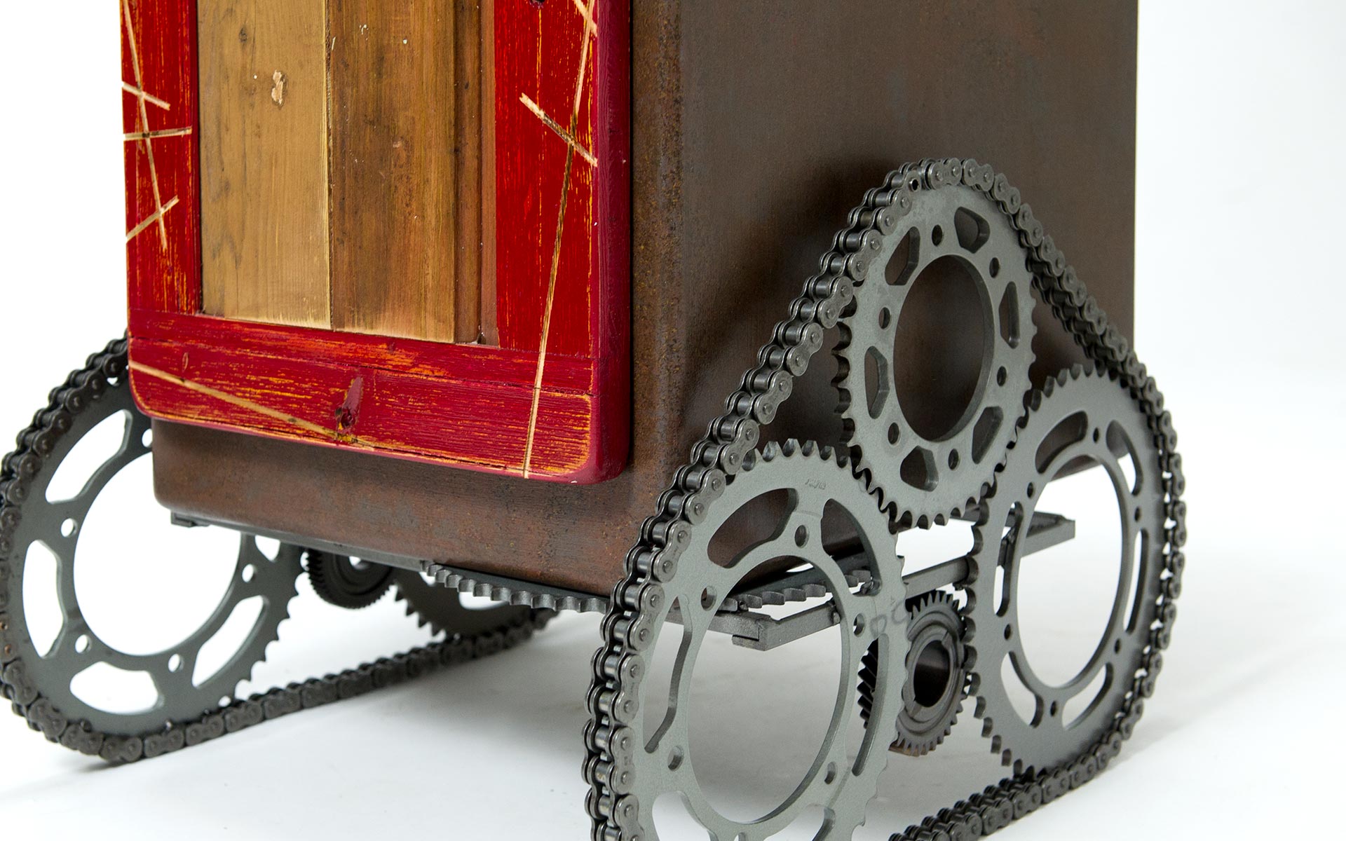 Dettaglio di un mobile di art design in cui le ruote sono create con degli ingranaggi di una bicicletta e una catena
